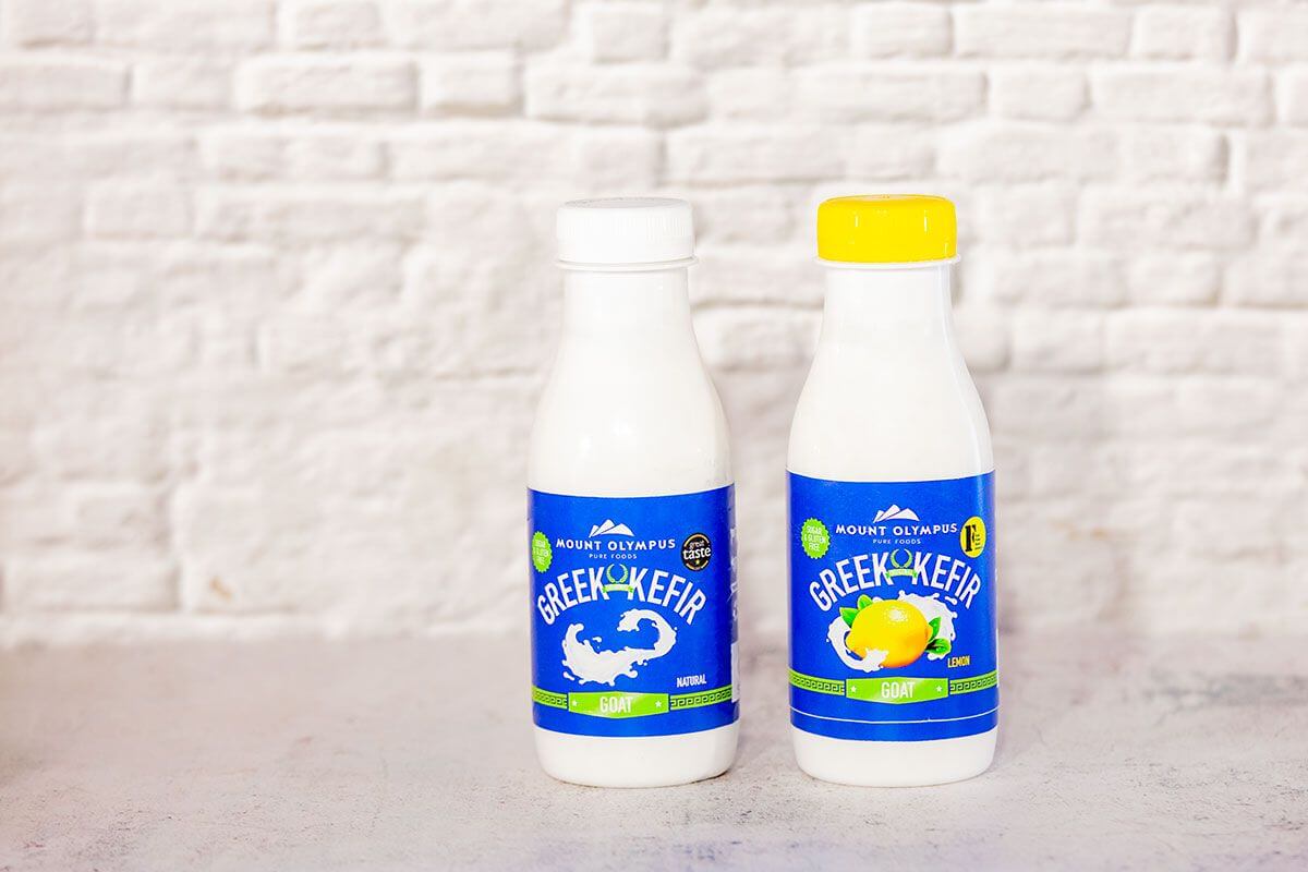Greek Goats Milk Kefir Duo Bundle - Original and Lemon bottles on a textured background, promoting gut health and probiotics.